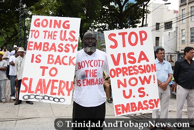 Addil Abdullah held placards protesting U.S. visa policy during the Emancipation Celebrations in Port of Spain