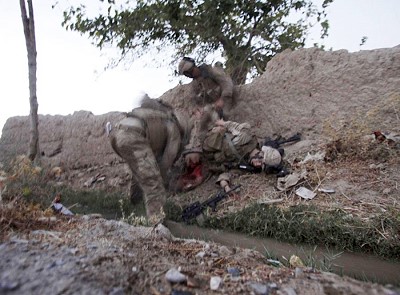 In this photo taken Friday, Aug. 14, 2009, Lance Cpl. Joshua Bernard is tended to by fellow U.S. Marines after being hit by a rocket propelled grenade during a firefight against the Taliban in the village of Dahaneh in the Helmand Province of Afghanistan. Bernard was transported by helicopter to Camp Leatherneck where he later died of his wounds. (AP Photo/Julie Jacobson)