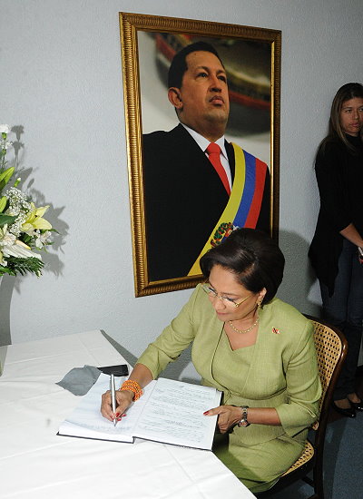 Prime Minister Kamla Persad-Bissessar signs the Condolence book at the Venezuelan Embassy